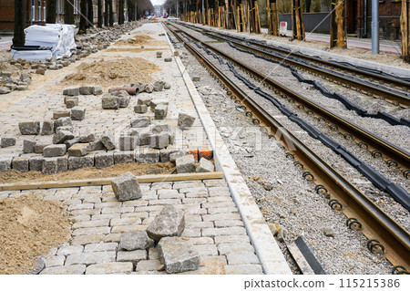 Street reconstruction, tree trunks with board covers, newly replaced tram rails, unfinished pavement 115215386