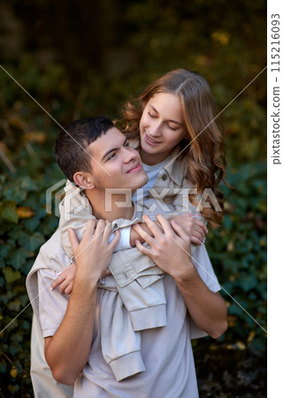 Warm Embrace of Teen Love in the Autumn Park. Capturing Teen Moments: Love Blossoms in Autumn's Embrace. Teenagers in Love: Embracing the Autumn Vibe 115216093