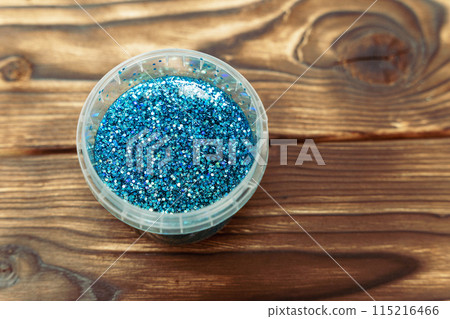 A close-up of a container filled with blue glitter 115216466