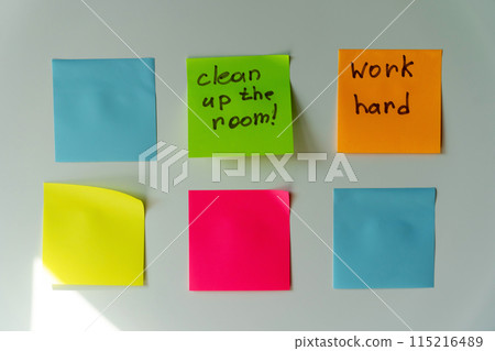 Six colorful sticky notes with handwritten reminders on a white surface. clean the room, work hard Six colorful sticky notes with handwritten reminders on a white surface. clean the room, work hard 115216489
