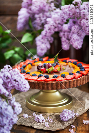 Delicious homemade chocolate tart decorated with fresh strawberry, blueberry, apricot and cherry 115216541