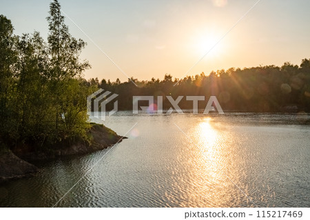 Sunset over lake, sunlight reflecting on water, creating beautiful landscape 115217469