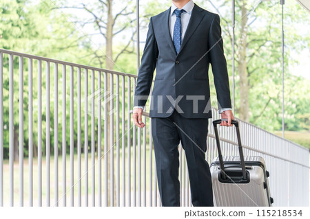 A businessman walking with a suitcase on a business trip, transfer, transfer, promotion, etc. A businessman walking with a suitcase on a business trip, transfer, transfer, promotion, etc. 115218534