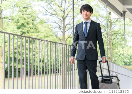 A businessman walking with a suitcase on a business trip, transfer, transfer, promotion, etc. A businessman walking with a suitcase on a business trip, transfer, transfer, promotion, etc. 115218535