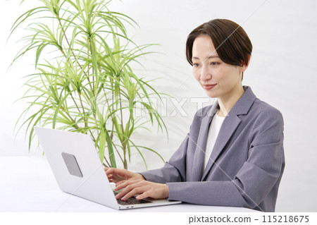A businesswoman doing desk work using a computer in the office 115218675