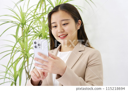 Young business woman using smartphone in office 115218694