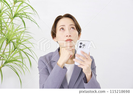 女商人在辦公室思考時使用智慧型手機 115218698