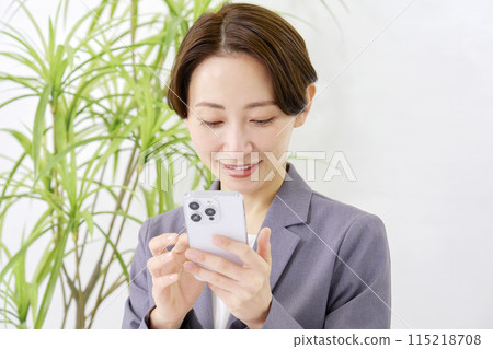 Business woman using a smartphone in the office Business woman using a smartphone in the office 115218708