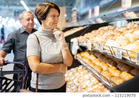 Woman and man walking through the supermarket Woman and man walking through the supermarket 115219070