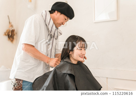 A male hairdresser/stylist applying a shampoo cloth to a female customer at a beauty salon A male hairdresser/stylist applying a shampoo cloth to a female customer at a beauty salon 115220616
