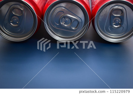 close up group of aluminium red cans soft drink put on blue texture background 115220979