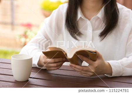 在開放式咖啡館讀書的年輕女子 115224781