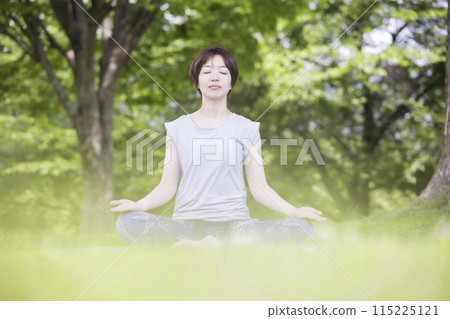 A young woman sitting cross-legged outside - Outdoor yoga image A young woman sitting cross-legged outside - Outdoor yoga image 115225121