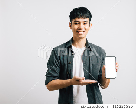 Portrait Asian smiling young man show mobile phone blank screen and hand open studio shot isolated white background, Happy excited lifestyle men hold smartphone present something on palm and screen Portrait Asian smiling young man show mobile phone blank screen and hand open studio shot isolated white background, Happy excited lifestyle men hold smartphone present something on palm and screen 115225580