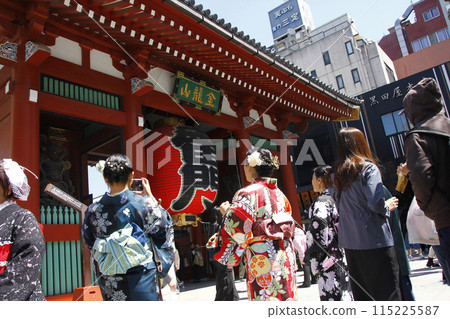 Young women in kimono take a commemorative photo in front of Kaminarimon Gate. They are filled with joy at wearing kimono for the first time and cheer loudly. 115225587