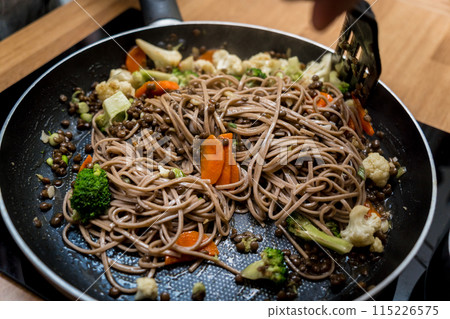 Chef at the kitchen preparing japanese buckwheat pasta with lentils Chef at the kitchen preparing japanese buckwheat pasta with lentils 115226575