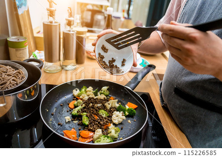 Chef at the kitchen preparing japanese buckwheat pasta with lentils 115226585