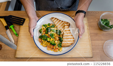 Chef at the kitchen preparing tofu scramble with vegetables Chef at the kitchen preparing tofu scramble with vegetables 115226656