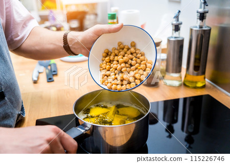 Chef at the kitchen preparing chickpea porridge with ginger Chef at the kitchen preparing chickpea porridge with ginger 115226746