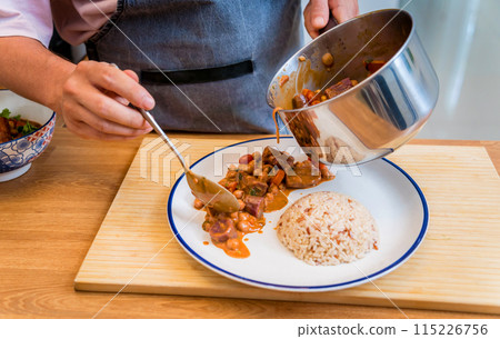 Chef at the kitchen preparing massaman curry with sweet potato and many spices Chef at the kitchen preparing massaman curry with sweet potato and many spices 115226756