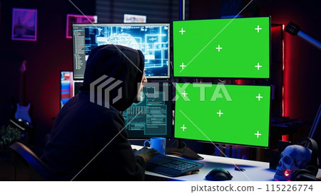 Hacker using AI and green screen computer monitors to produce malicious malware corrupt company data. Evil man working on mockup desktop PC using artificial intelligence, infecting systems, camera B 115226774