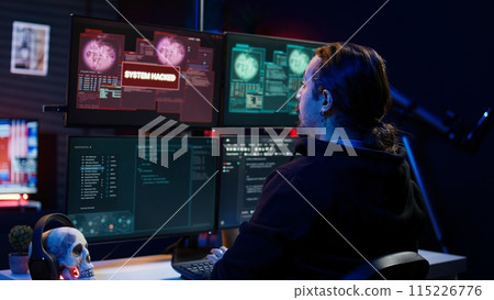 Happy hacker in apartment having burst of joy after managing to steal valuable data, using phishing technique that tricks users into revealing sensitive information, camera B 115226776