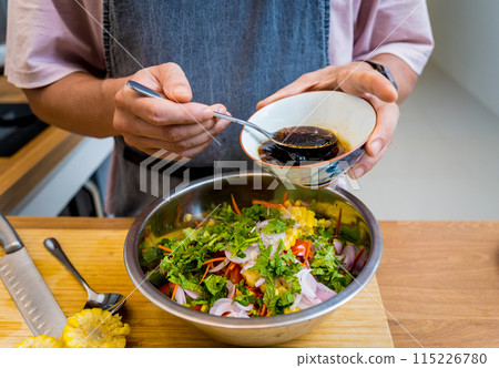 Chef at the kitchen preparing spicy glass noodle salad 115226780