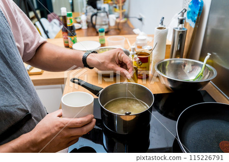 Chef at the kitchen preparing rice porridge with onion and sesame seeds 115226791