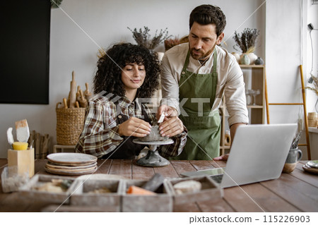 Pottery workshop with two people crafting ceramic piece together Pottery workshop with two people crafting ceramic piece together 115226903