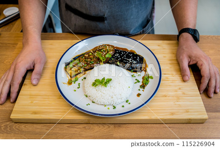 Delicious grilled eggplants with garlic on the white plate Delicious grilled eggplants with garlic on the white plate 115226904