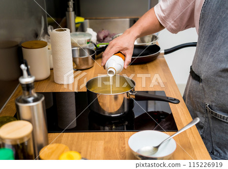 Chef at the kitchen preparing green curry with herbs and rice 115226919