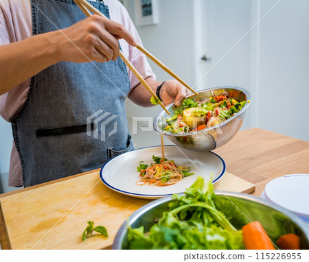Chef at the kitchen preparing spicy glass noodle salad Chef at the kitchen preparing spicy glass noodle salad 115226955
