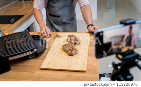 The chef is broadcasting live from workshop how to prepare a beef steaks on the electric grill 115226976