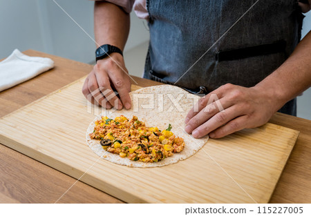 Chef at the kitchen preparing quesadillas with tofu and sweet corn 115227005