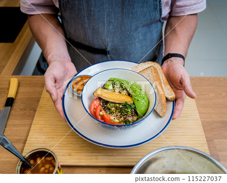 Chef at the kitchen preparing healthy quinoa bowl with avocado Chef at the kitchen preparing healthy quinoa bowl with avocado 115227037