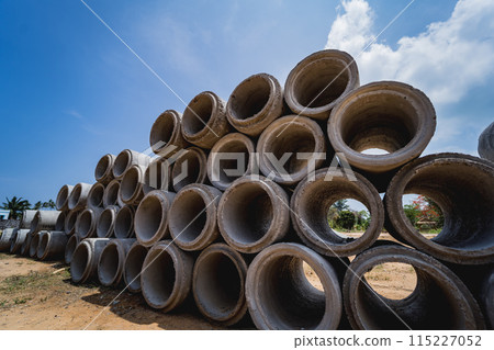 A stack of concrete ring pipes piled and creating a symmetrical arrangement 115227052