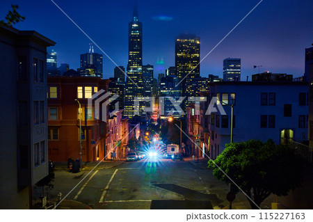 Bright car lights coming up hill from foggy night over downtown San Francisco skyscrapers Bright car lights coming up hill from foggy night over downtown San Francisco skyscrapers 115227163