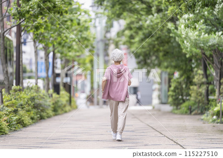 Back view of a walking senior woman 115227510