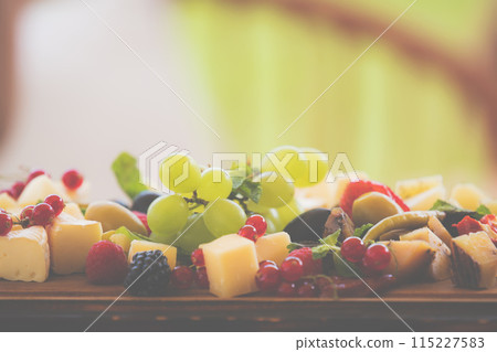 Cheese plate with berries. delicious appetizer for aperitif, copy space outdoor. 115227583
