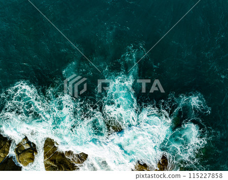 Bird eye view seashore with big wave crashing on rock cliff. Beautiful waves sea surface in sunny day summer background, Amazing seascape top view seacoast landscape view 115227858