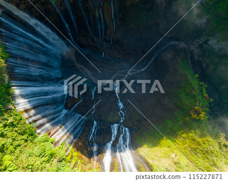 Aerial view of Panorama Tumpak Sewu Waterfalls also known as Coban Sewu.Beautiful rainbow and fog,Tumpak Sewu Waterfalls are a tourist attraction in East Java, Indonesia.Amazing travel destination 115227871