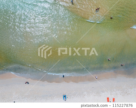 Aerial view of Waves crashing on sandy shore,Sea surface ocean waves background,Top view beach background Aerial view of Waves crashing on sandy shore,Sea surface ocean waves background,Top view beach background 115227876