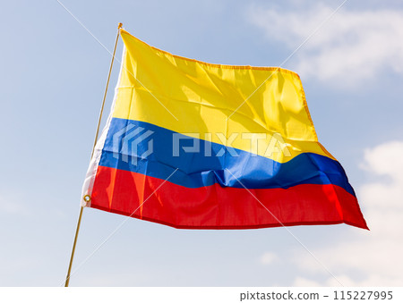 National flag of Colombia waving on flagpole against blue sky 115227995