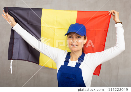 Smiling adult woman in uniform holding Belgium flag Smiling adult woman in uniform holding Belgium flag 115228049