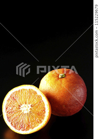 Blood orange photographed against a black background Blood orange photographed against a black background 115229679