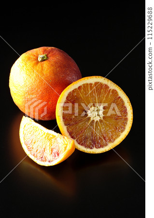 Blood orange photographed against a black background 115229688