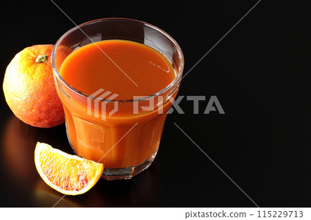 Blood orange juice photographed against a black background 115229713