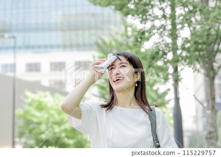 擔心陽光的女人用手帕擦去額頭的汗水 115229757