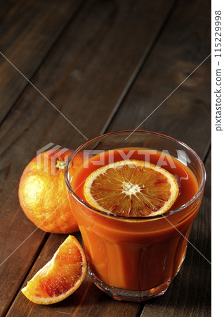Blood orange juice with slices of fruit floating in it Blood orange juice with slices of fruit floating in it 115229998