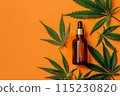 dropper bottle with CBD oil and green cannabis leaves on orange background 115230820